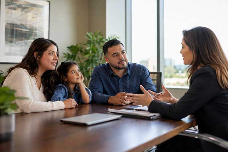 Familia reunida con una abogada para revisar opciones de residencia con TPS